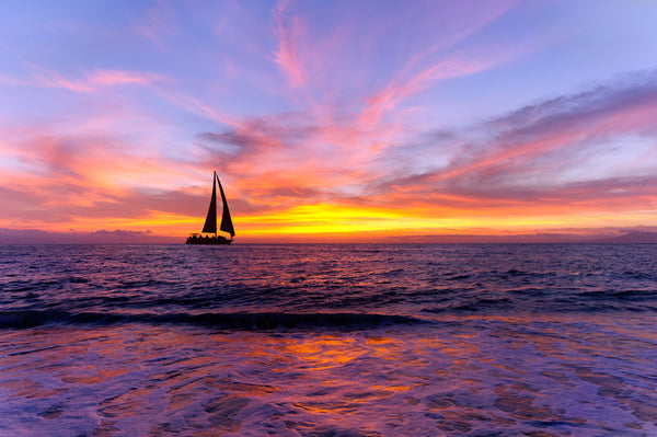 SAILBOAT ON PURPLE WATER AND BLUE SKY AT SUNSET