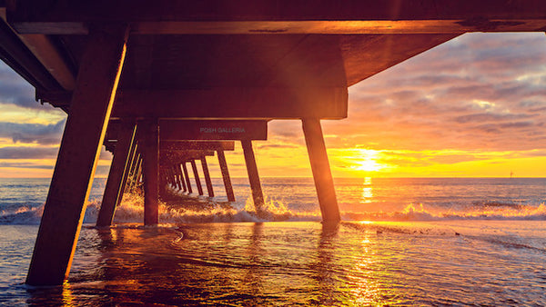 UNDER VIEW OF PIER WITH GOLDEN SUNSET